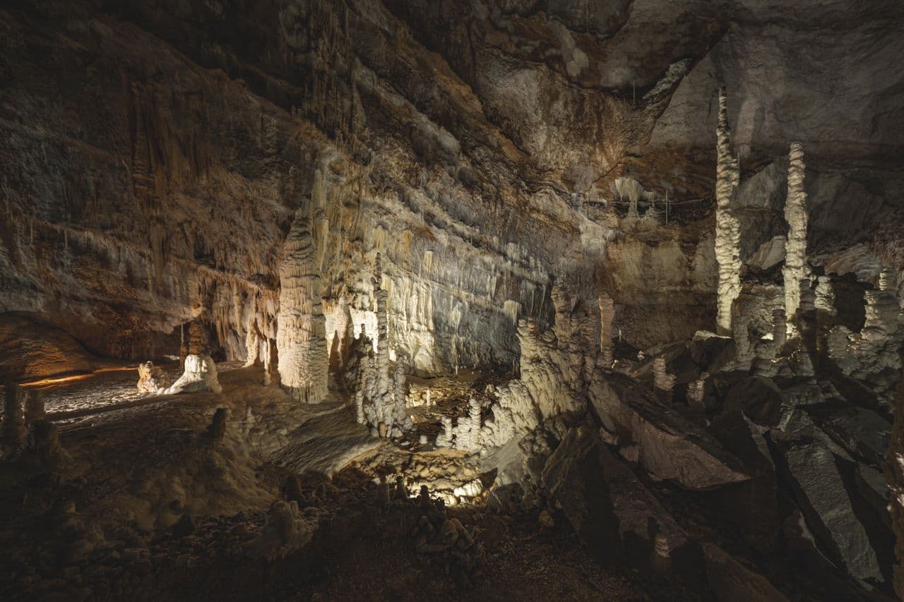 Limestone cave interior in Meghalaya with stalactites hanging from the roof and stalagmites rising from the floor for UPSC geography
